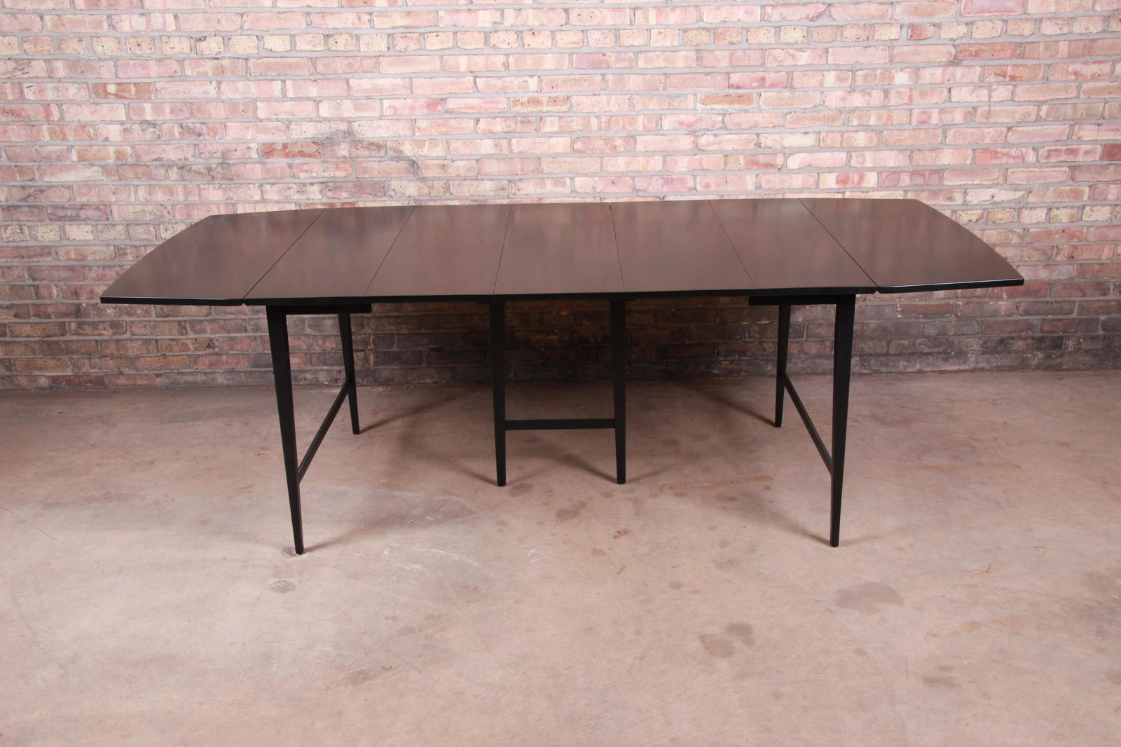 Authentic Paul McCobb Planner Group Mid-Century Modern: A sleek and stylish mid-century modern extension drop leaf dining table By Paul McCobb for Winchendon Furniture "Planner Group" USA 1950s Solid maple construction with black lacquered finish. Measures