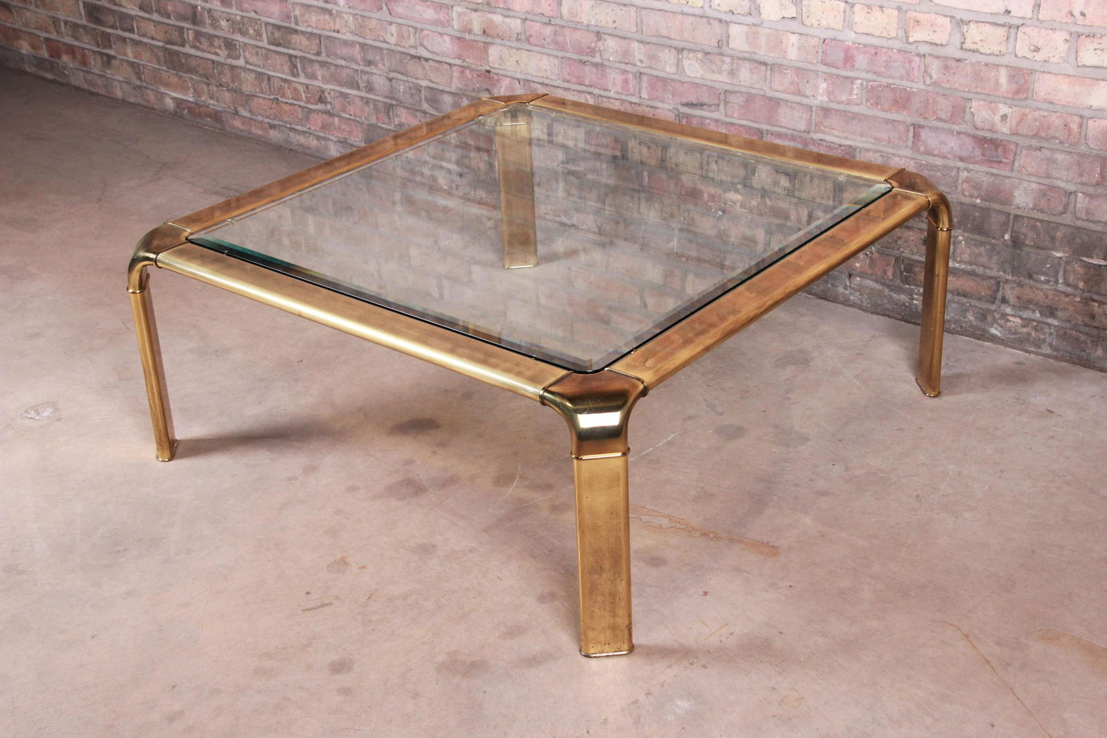 Authentic John Widdicomb Hollywood Regency Brass and: An exceptional mid-century modern Hollywood Regency coffee or cocktail table By John Widdicomb USA Circa 1970s Brass frame with beveled glass top. Measures: 40"W x 40"D x 16"H. Very good original vint
