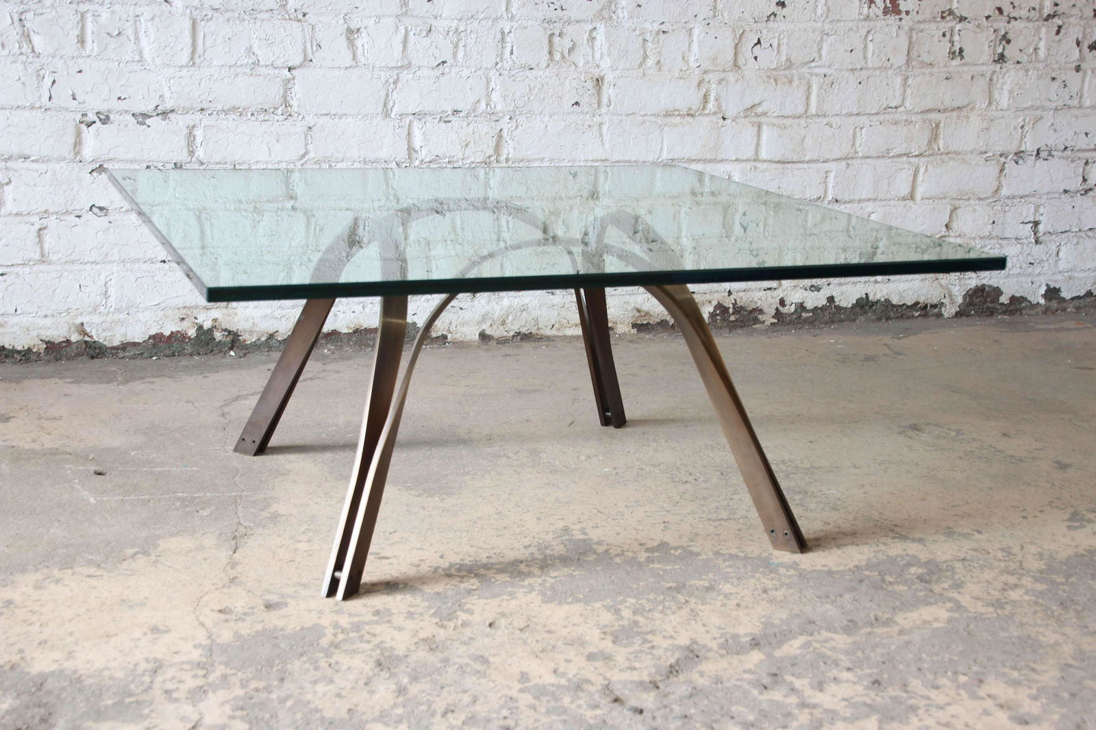 Authentic Roger Sprunger Style Mid-Century Brass and: Offering a nice mid-century modern brass and glass coffee table in the style of Roger Sprunger. The square glass fits onto the brass frame nicely and the base can be reversed as the class can sit on b