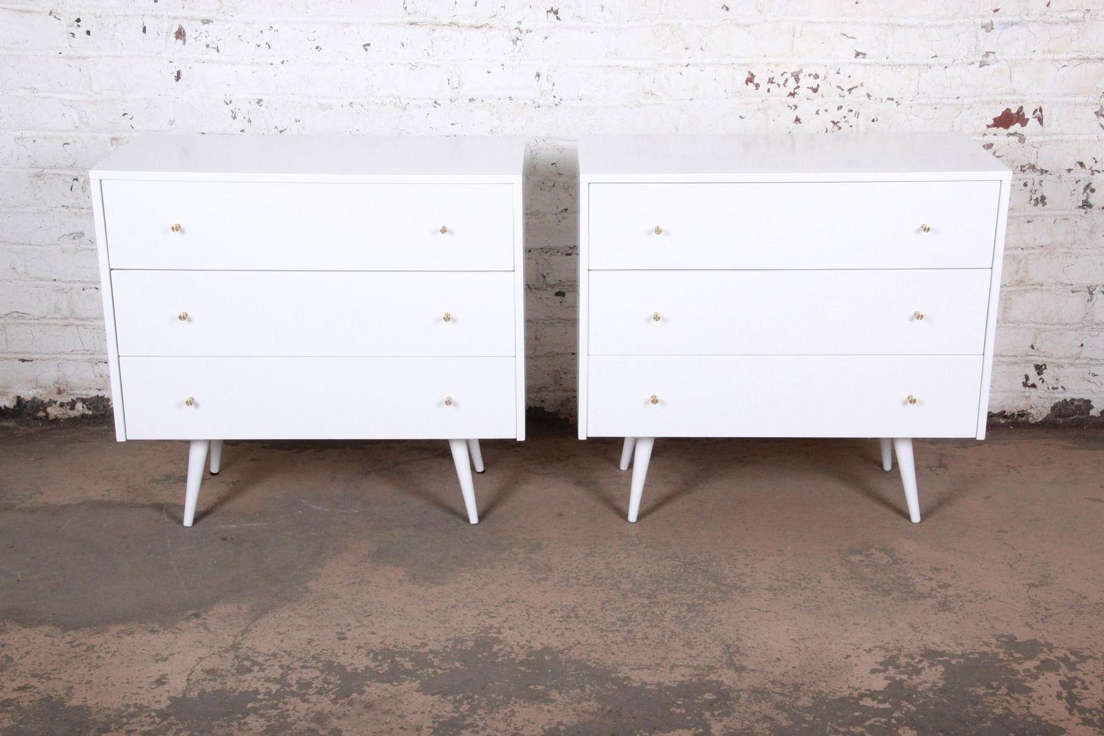 Authentic Paul McCobb Planner Group White Lacquered: An exceptional pair of mid-century modern bachelor chests or bedside tables Designed by Paul McCobb for Winchendon Furniture "Planner Group" USA 1950s Birch + white lacquer + brass hardware Measures: