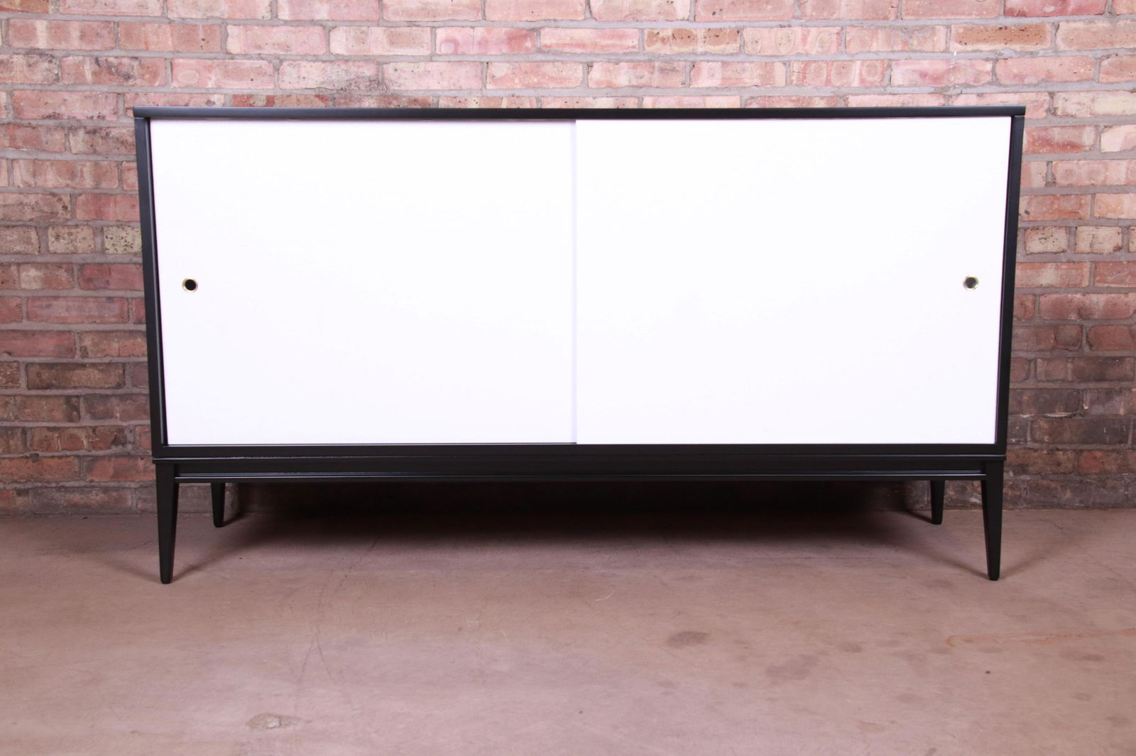 Authentic Paul McCobb Planner Group Black and White: A rare and exceptional mid-century modern sideboard credenza or bar cabinet By Paul McCobb for Winchendon Furniture "Planner Group" USA 1950s Black lacquered solid birch with white grass cloth sliding