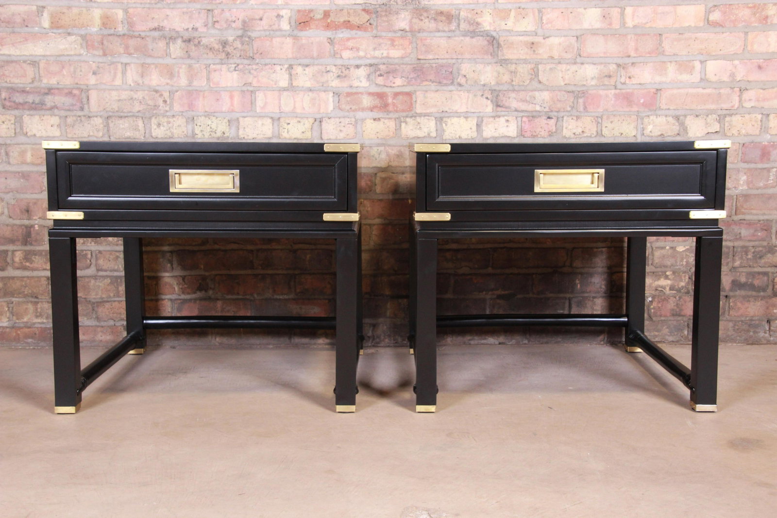 Authentic Hollywood Regency Campaign Black Lacquered: A gorgeous pair of mid-century modern Hollywood Regency Campaign style nightstands or end tables Attributed to Ficks Reed USA Circa 1960s Black lacquered wood with faux bamboo stretchers and brass har