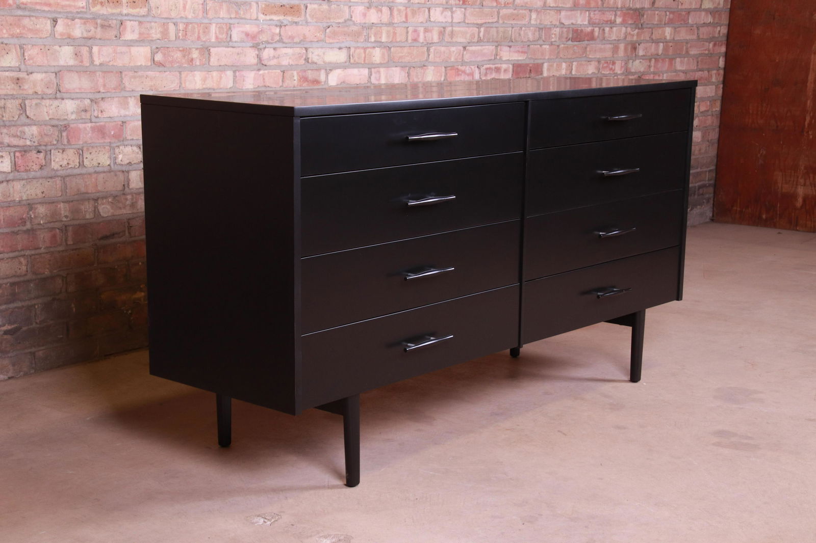 Authentic Paul McCobb Planner Group Black Lacquered: An exceptional mid-century modern eight-drawer dresser or credenza By Paul McCobb for Winchendon Furniture "Planner Group" USA 1950s Black lacquered solid birch with original sculpted birch and alumin
