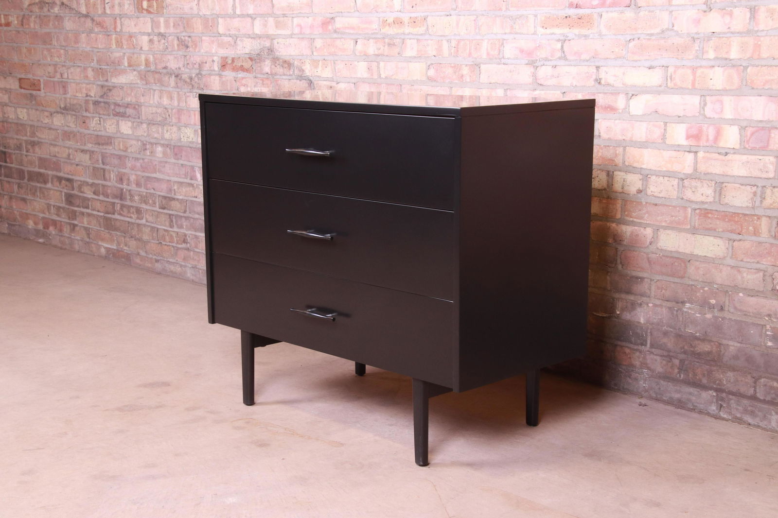 Paul McCobb Planner Group Black Lacquered Chest of: An exceptional mid-century modern three-drawer dresser chest By Paul McCobb for Winchendon Furniture "Planner Group" USA 1950s Black lacquered solid birch with original sculpted birch and aluminum har