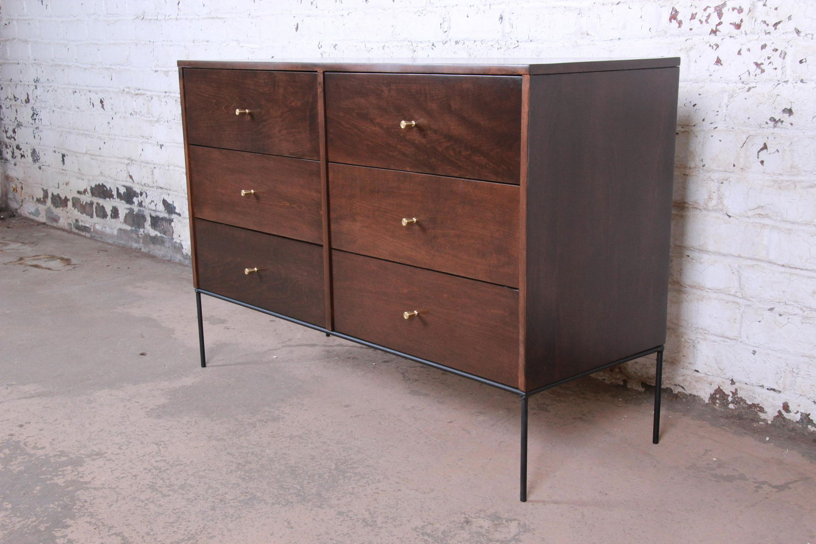 Paul McCobb Planner Group Iron Base Six-Drawer Dresser: An exceptional mid-century modern six-drawer dresser or credenza from the Planner Group line designed by Paul McCobb for Winchendon Furniture. The dresser features solid maple construction with stunni