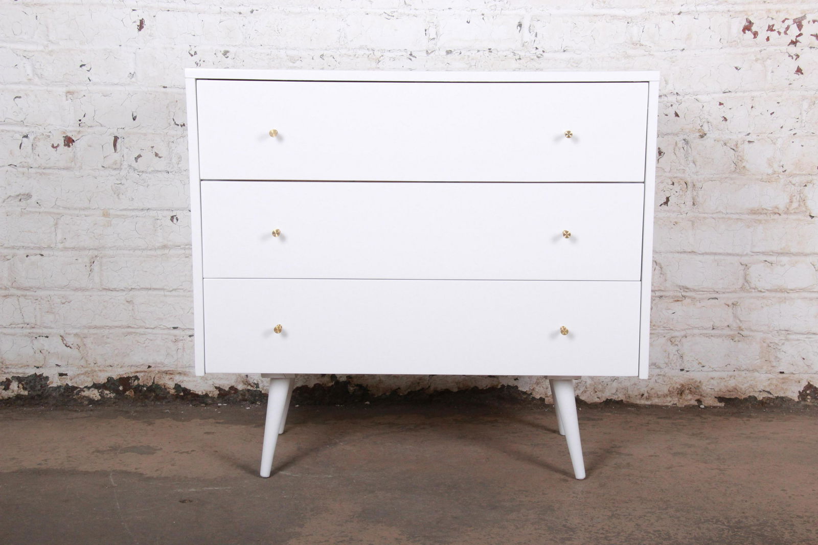 Paul McCobb Planner Group White Lacquered Three Drawer: An exceptional mid-century modern bachelor chest or bedside table Designed by Paul McCobb for Winchendon Furniture "Planner Group" USA 1950s Birch + white lacquer + brass hardware Measures: 36"W x 19"