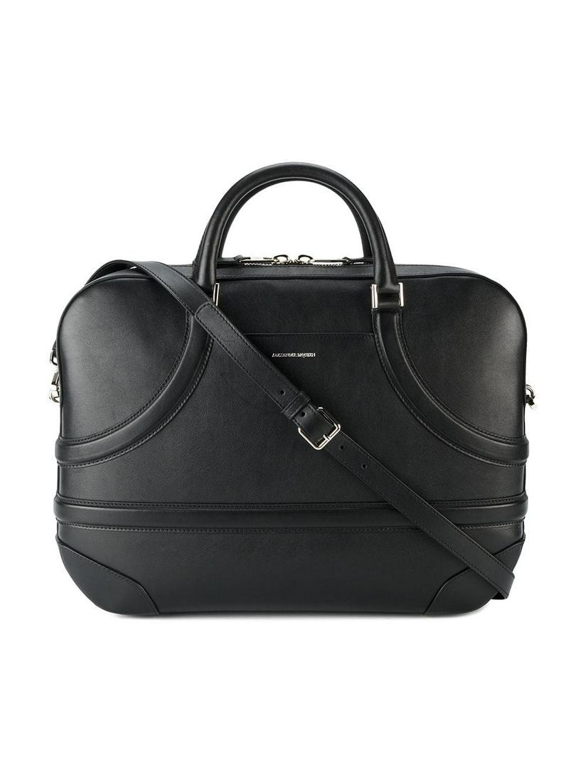 Authentic Alexander McQueen Leather Harness Briefcase: The Harness briefcase features a leather body an exterior slip pocket rolled leather handles a flat detachable strap a 2 way top zip closure and interior zip and slip pockets. Brand: Alexander McQueen