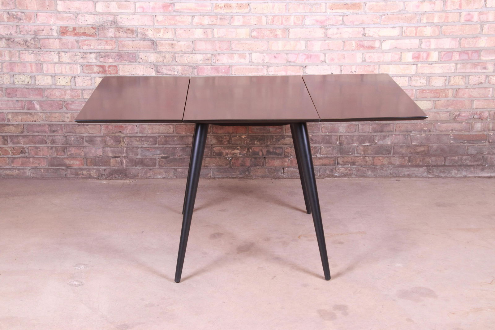 Paul McCobb Planner Group Mid-Century Modern Black: An exceptional mid-century modern black lacquered solid birch drop leaf dining table By Paul McCobb for Winchendon Furniture "Planner Group" USA 1950s Measures: 56.5"W x 36"D x 29.13"H. Measures 23.5"