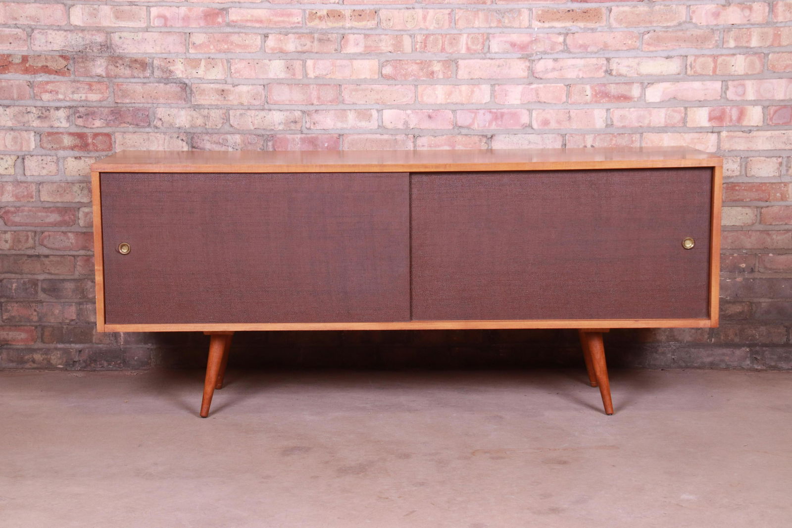Paul McCobb Planner Group Mid-Century Modern Credenza: An exceptional minimalist mid-century modern sliding door credenza or record cabinet By Paul McCobb for Winchendon Furniture "Planner Group" USA 1950s Solid maple with sliding grass cloth doors. Measu