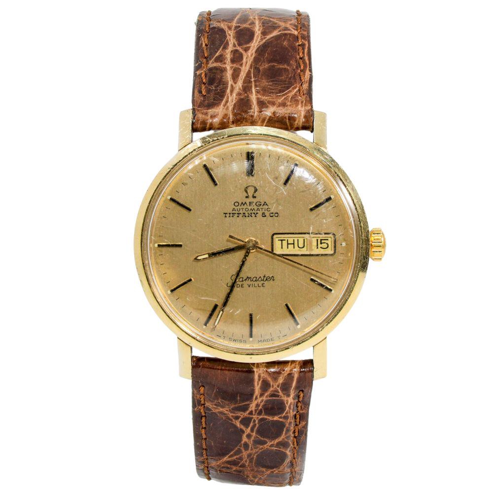 Authentic Omega Tiffany & Co. Seamaster DeVille 14K: Omega Tiffany & Co. Seamaster DeVille 14K Yellow Gold 32mm Brown Leather Strap Smooth Bezel Watch Manufacturer: TIFFANY & CO / OMEGA Condition: Gently Used MM: 32mm Reference Number: All Bidhaus items