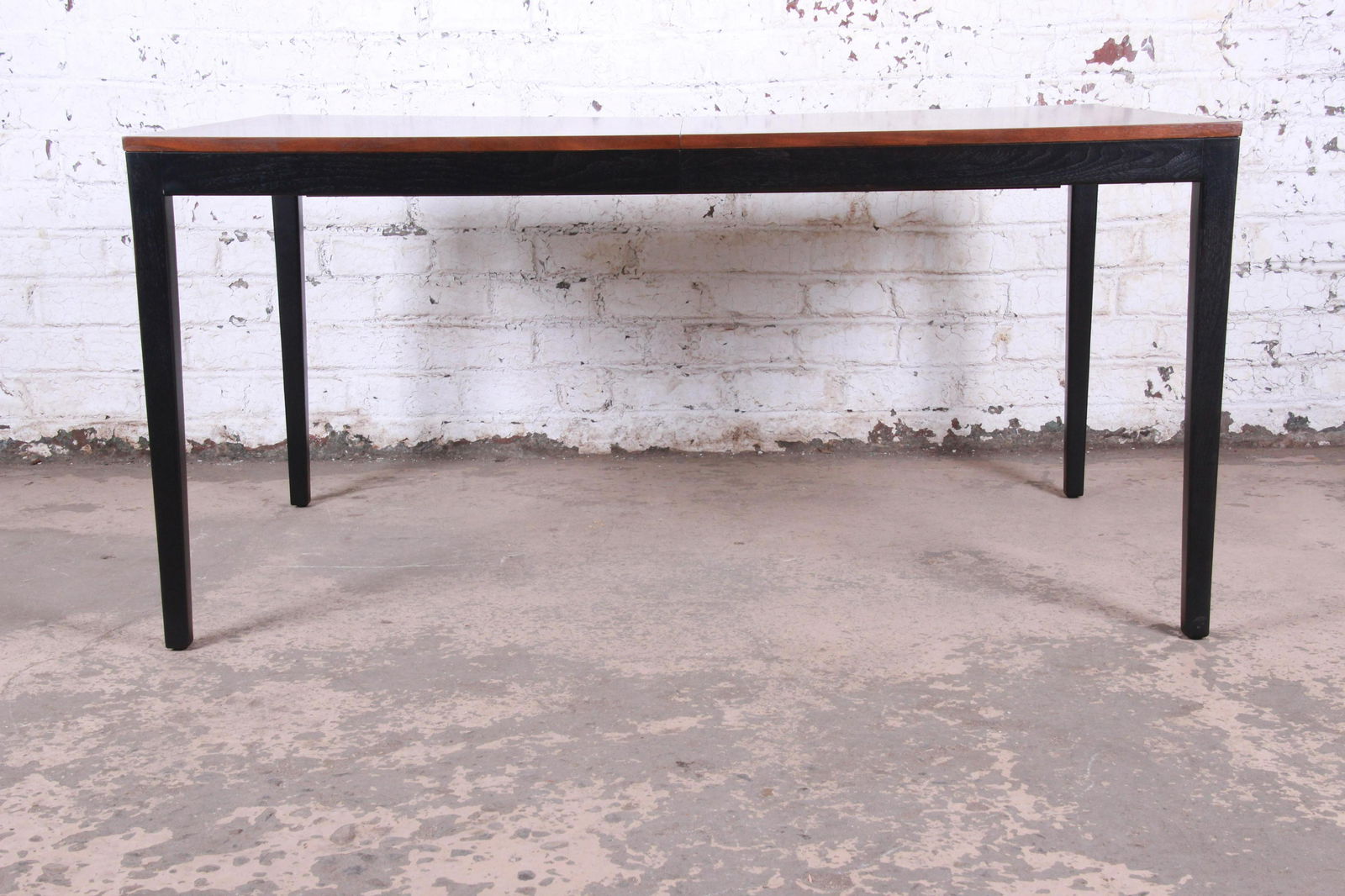 George Nelson for Herman Miller Walnut and Ebonized: A sleek and stylish minimalist mid-century modern dining table in book-matched walnut and ebonized wood By George Nelson for Herman Miller USA Circa 1960s Measures: 60"W x 36"D x 29.13"H. Extends up t