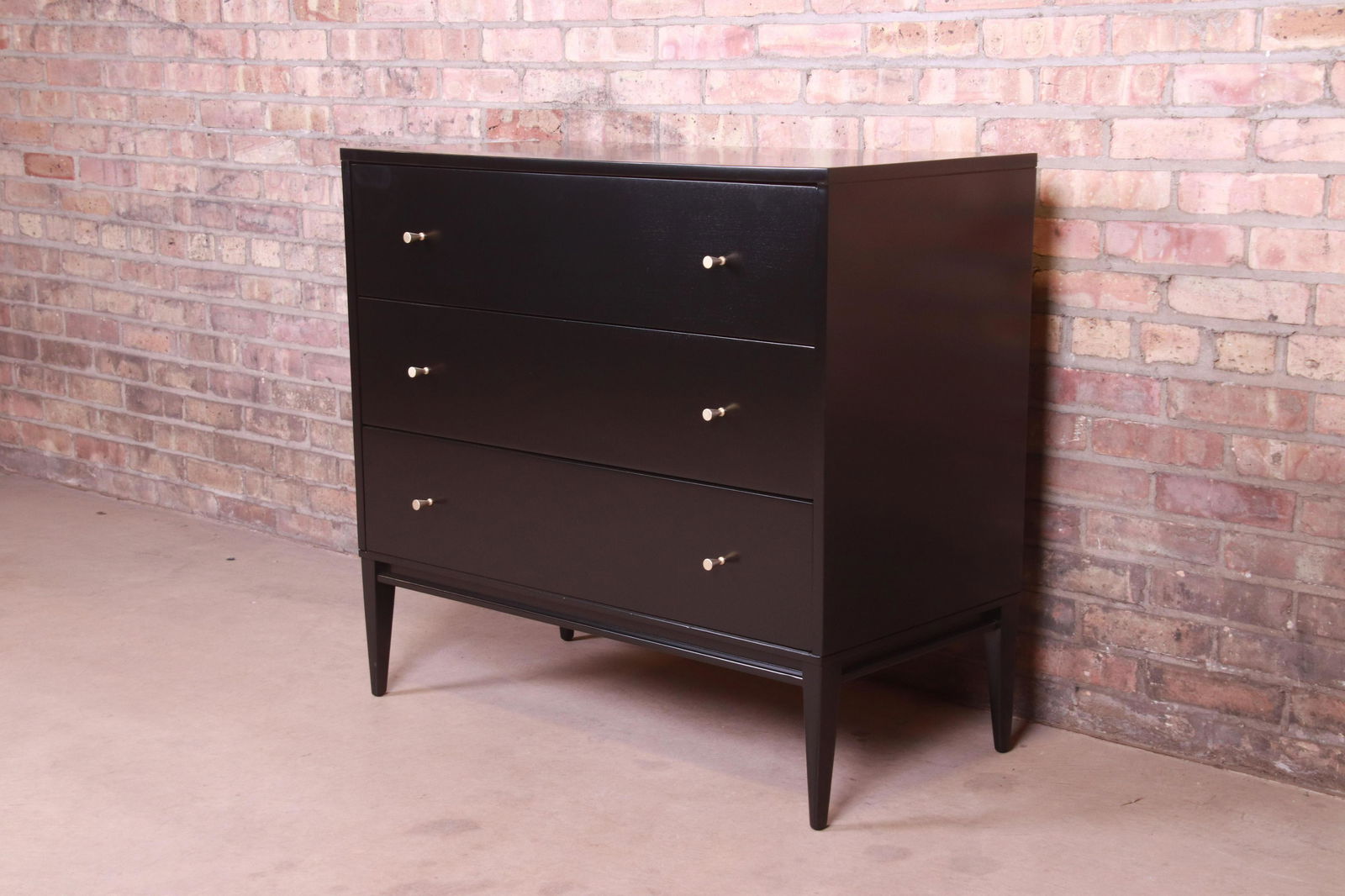 Paul McCobb Planner Group Black Lacquered Bachelor: A sleek and stylish mid-century modern chest of drawers By Paul McCobb for Winchendon Furniture "Planner Group" USA 1950s Black lacquered solid birch with original brass hardware. Measures: 36"W x 18.