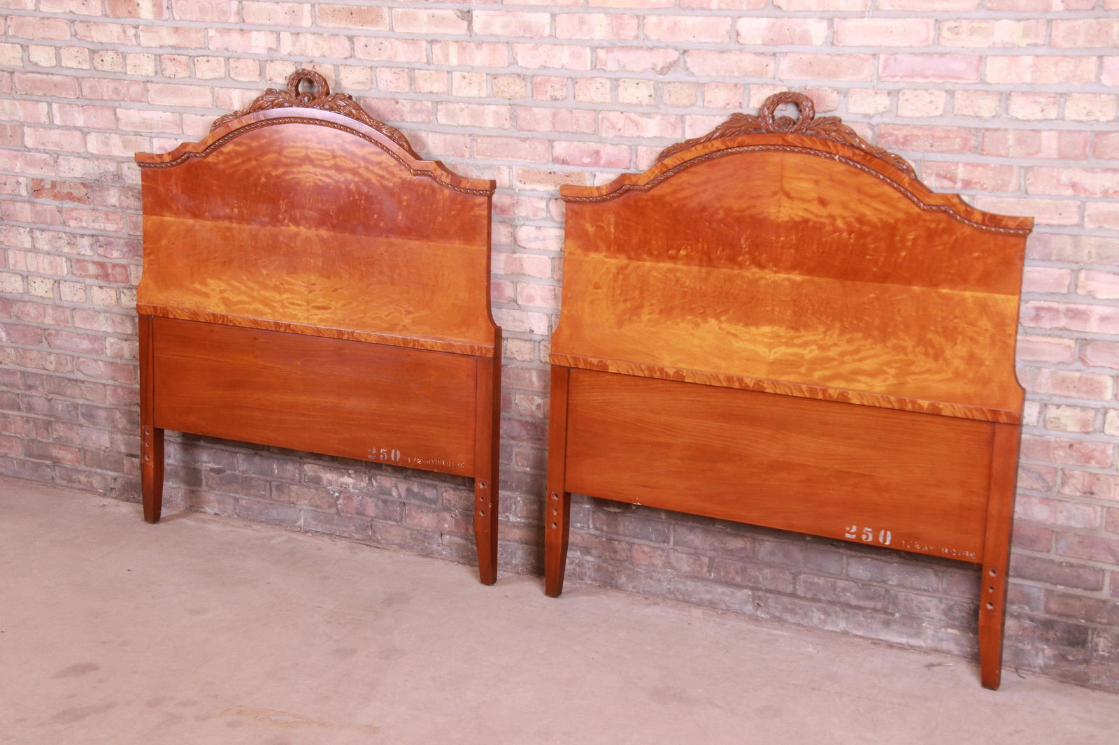 French Provincial Burl Wood Twin Headboards Attributed: A gorgeous pair of French Provincial twin size headboards Attributed to Romweber USA Circa 1940s Exotic burled African avodire wood with carved floral details. Measures: 42.13"W x 1.88"D x 48.25"H. Ex