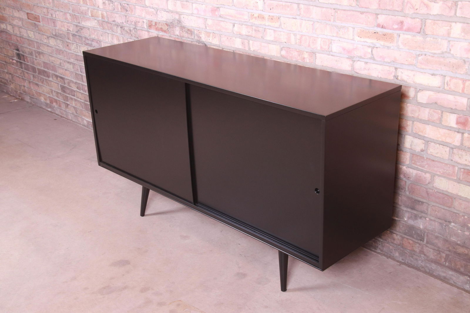 Paul McCobb Planner Group Mid-Century Modern Black: An exceptional minimalist mid-century modern sliding door sideboard credenza or bar cabinet By Paul McCobb for Winchendon Furniture "Planner Group" USA 1950s Black lacquered solid maple. Measures: 60"