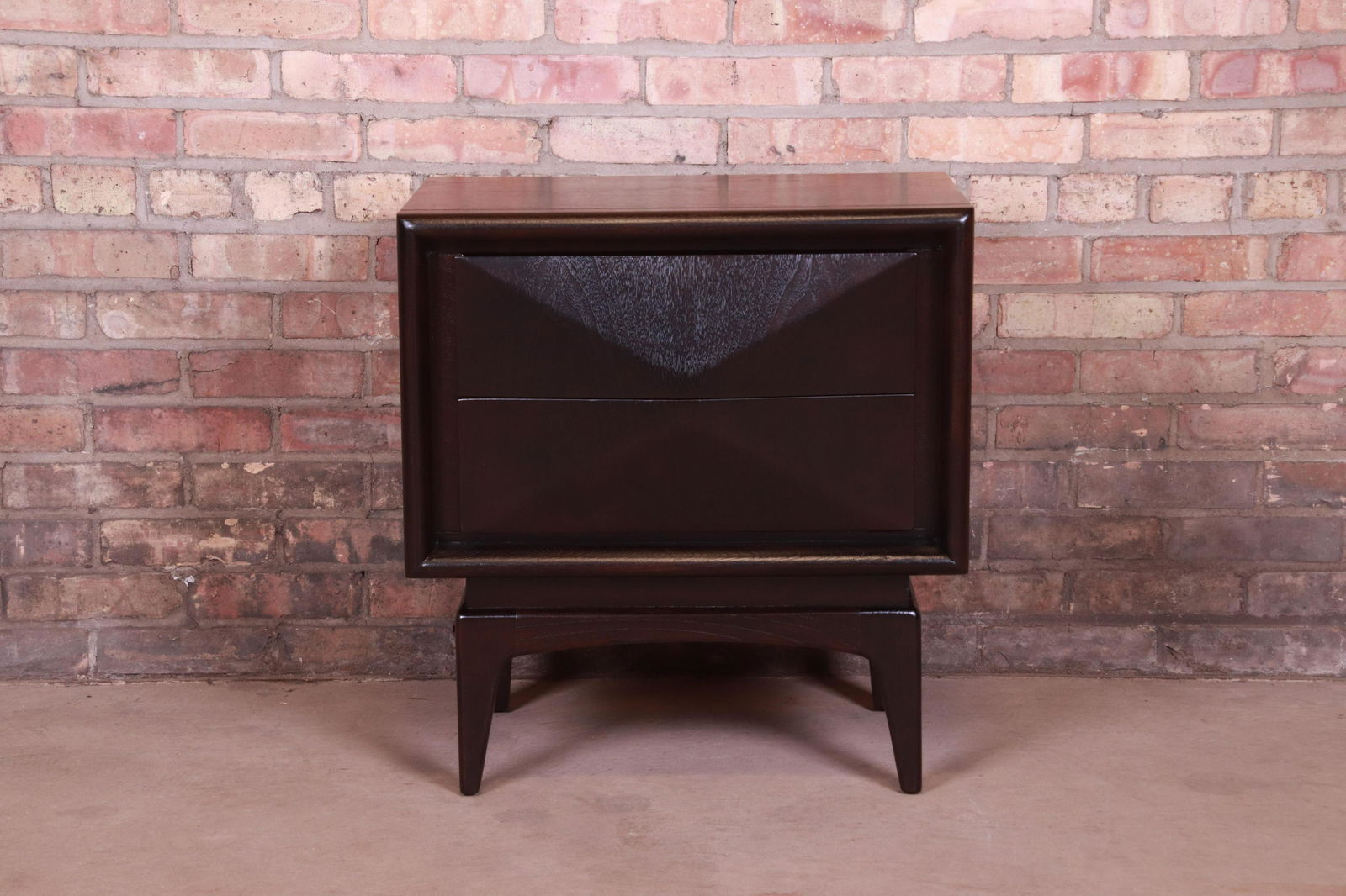 Mid-Century Modern Ebonized Sculpted Walnut Diamond: A stunning mid-century modern diamond front nightstand In the manner of Vladimir Kagan By United Furniture Co. USA 1960s Ebonized walnut with unique sculpted diamond front design. Measures: 23"W x 16"