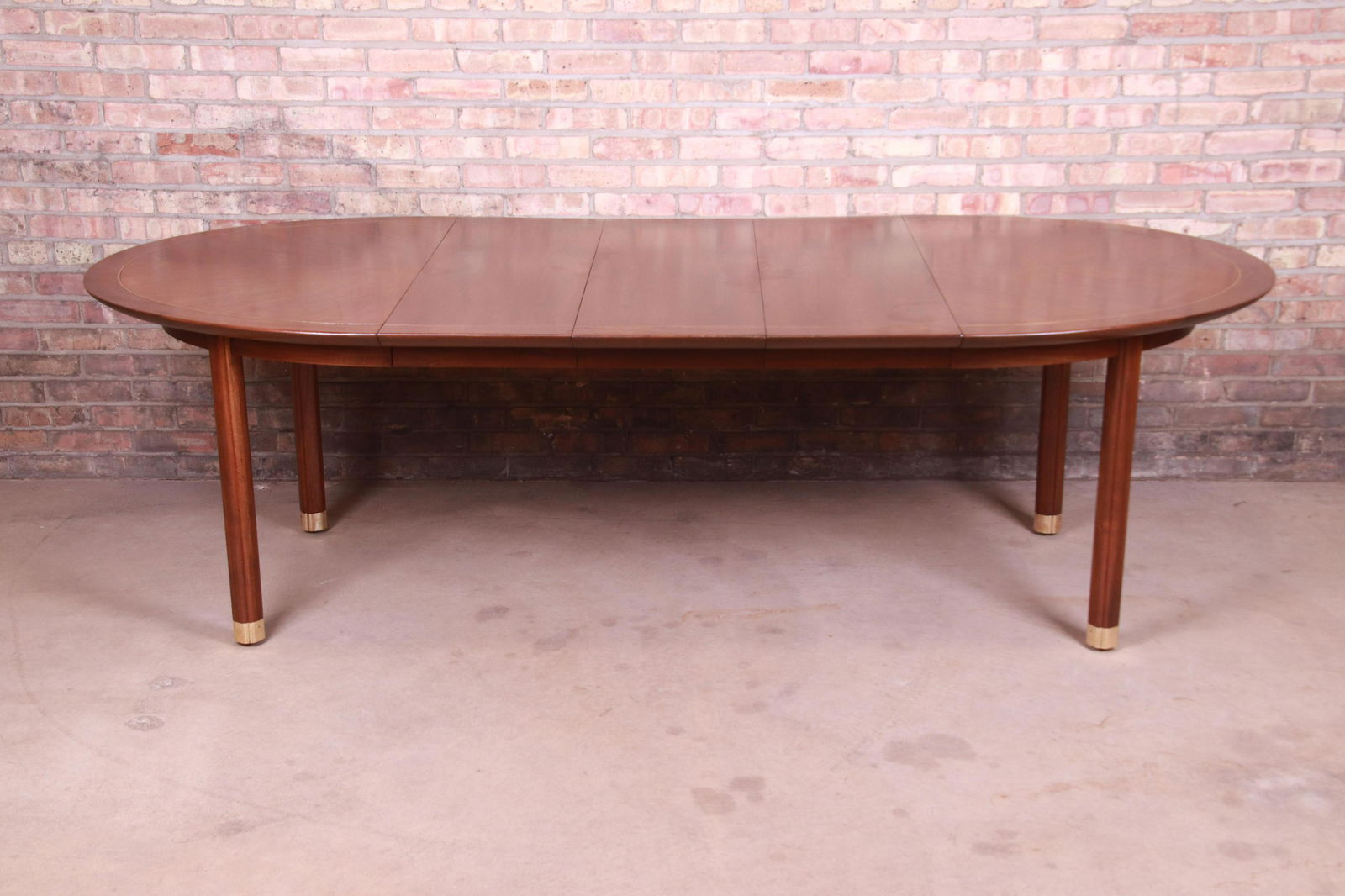 Michael Taylor for Baker Furniture Walnut and Brass: An exceptional mid-century modern Hollywood Regency Chinoiserie extension dining table By Michael Taylor for Baker Furniture "New World Collection" USA 1950s Book-matched walnut with brass inlay and b
