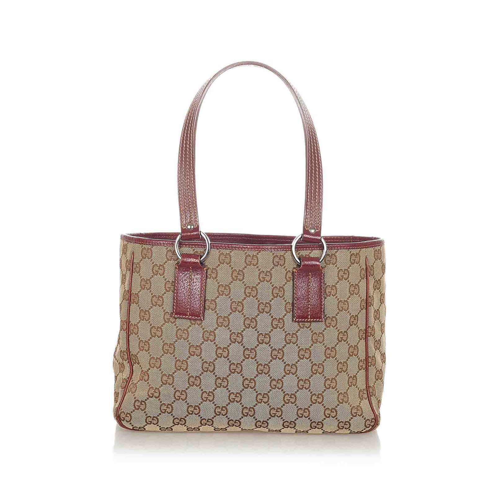 Authentic Gucci GG Canvas Handbag: This item qualifies for FREE DOMESTIC SHIPPING to customers in the USA This handbag features a canvas body with leather trim flat leather straps an open top and an interior zip pocket. Brand: Gucci Mo