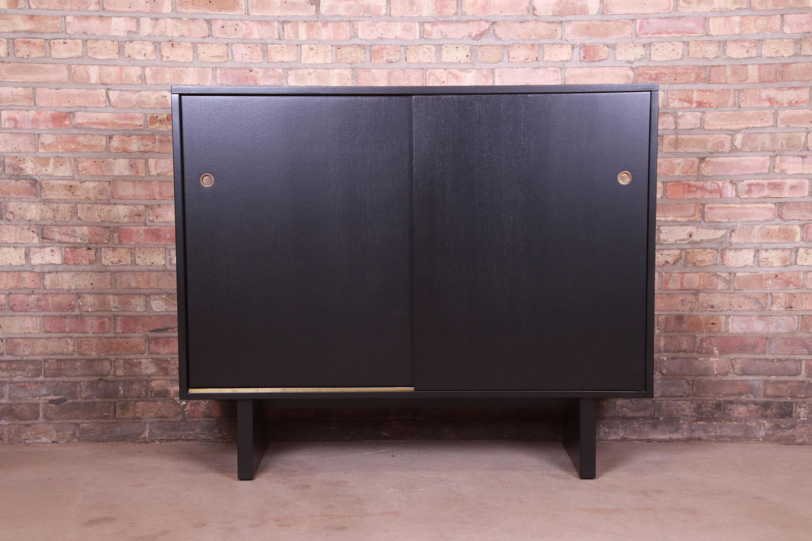 Robsjohn-Gibbings for Widdicomb Black Lacquered: An exceptional mid-century modern sliding door gentleman's chest By T.H. Robsjohn-Gibbings for Widdicomb (Retailed by John Stuart Inc.) USA 1950s Black lacquered walnut with original brass hardware. M