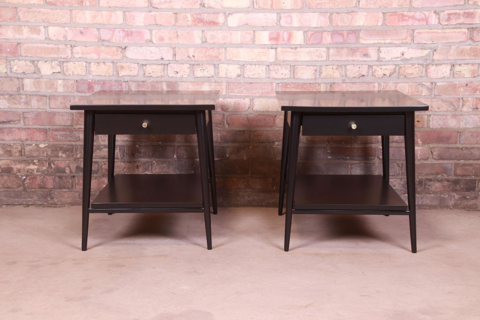 Paul McCobb Planner Group Black Lacquered Nightstands: A sleek and stylish pair of mid-century modern nightstands or side tables By Paul McCobb for Winchendon Furniture "Planner Group" USA 1950s Black lacquered solid maple with original brass drawer pulls