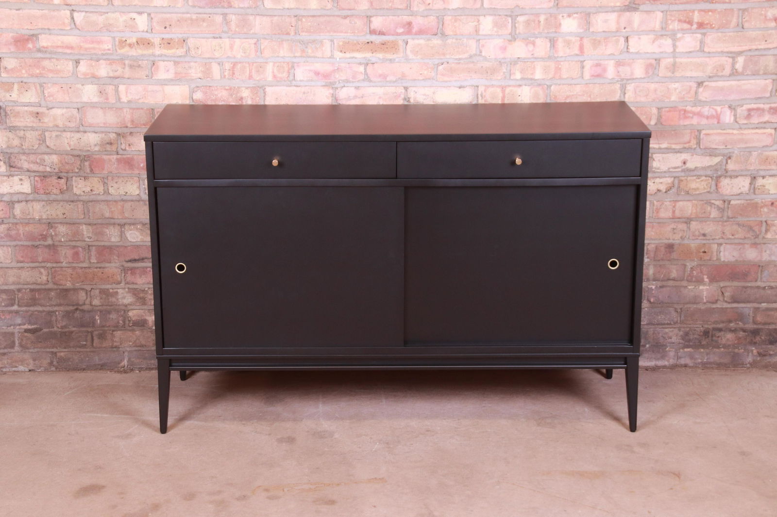 Paul McCobb Planner Group Mid-Century Modern Black: An exceptional minimalist mid-century modern sliding door sideboard credenza or bar cabinet By Paul McCobb for Winchendon Furniture "Planner Group" USA 1950s Black lacquered solid maple. Measures: 52"