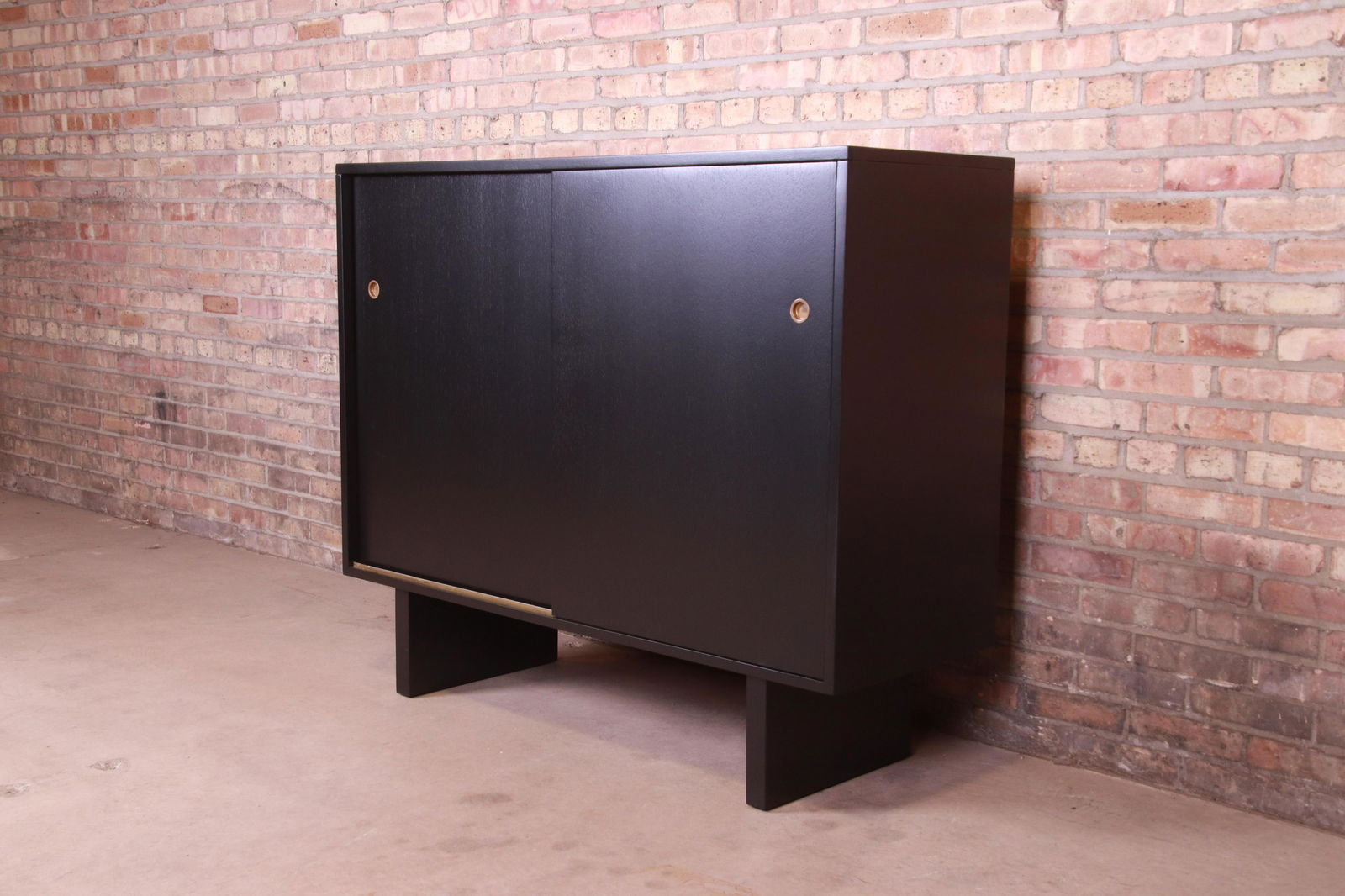 Robsjohn-Gibbings for Widdicomb Black Lacquered: An exceptional mid-century modern sliding door gentleman's chest By T.H. Robsjohn-Gibbings for Widdicomb (Retailed by John Stuart Inc.) USA 1950s Black lacquered walnut with original brass hardware. M
