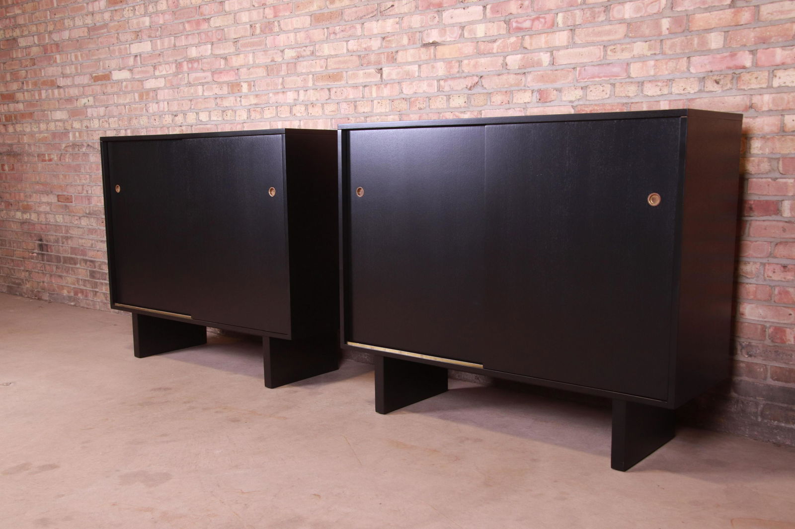 Robsjohn-Gibbings for Widdicomb Black Lacquered: An exceptional pair of mid-century modern sliding door gentleman's chests By T.H. Robsjohn-Gibbings for Widdicomb (Retailed by John Stuart Inc.) USA 1950s Black lacquered walnut with original brass ha