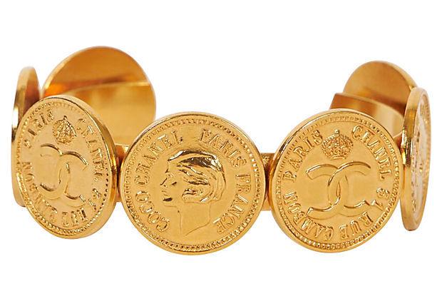 Authentic 1970s Chanel Logo Coins Cuff Bracelet: This item qualifies for FREE DOMESTIC SHIPPING to customers in the USA Condition: Excellent Era: Vintage; 1970s Dimensions: 2.5" W x 1" H Materials: metal Color: gold 1970s Chanel gold tone metal coin
