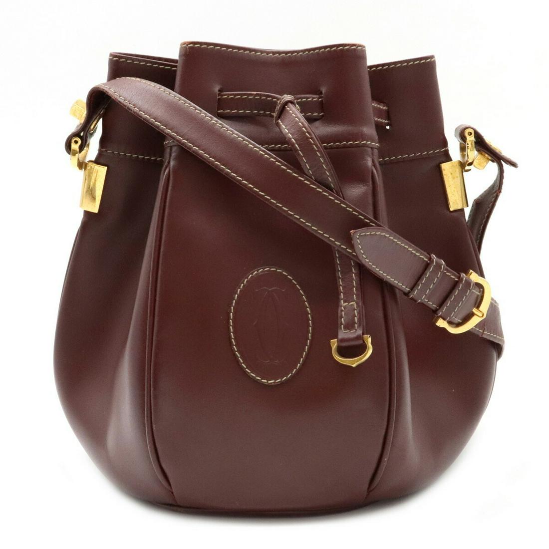 Authentic Cartier Mustline Drawstring Shoulder Bag: Brand: Cartier Type: Shoulder bag Condition: Used (good) Line: Must Material: Leather Color: Bordeaux Size (HxWxD): 23cm x 16cm x 16cm / 9.05'' x 6.29'' x 6.29'' Damage Ranking: Overall ,Crease ,- ,St