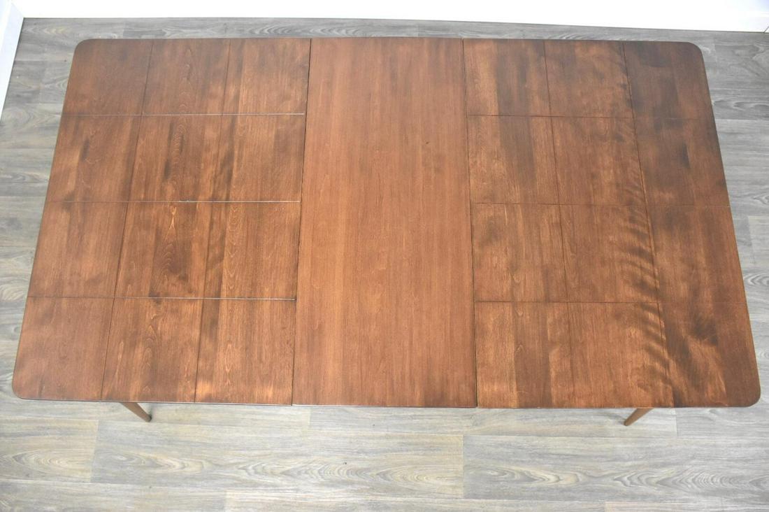 Mid-Century Modern Maple Extendable Dining Table: A mid century modern maple dining table with one 15 leaf that fully extends the table to 62.75 wide with canted legs in the style of Paul McCobb Planner Group. Professionally refinished. 36 wide. 47.7