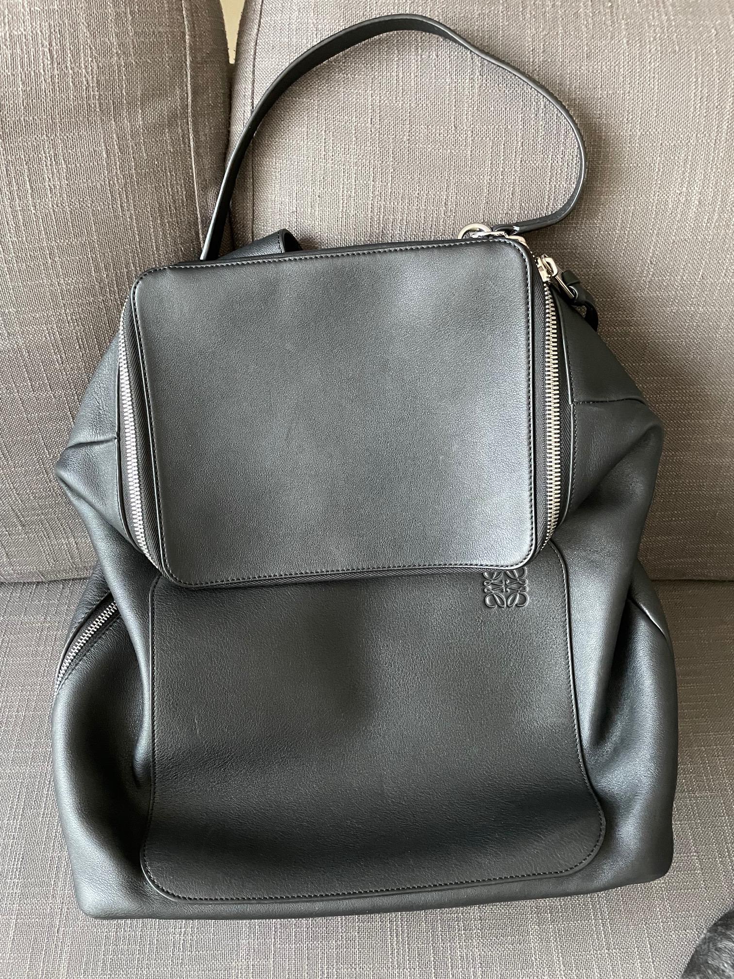 Loewe Goya Leather Backpack: Loewe Goya Leather Backpack The Goya features a leather body flat shoulder straps a flat handle a top zip closure and an interior zip and slip pocket. Brand: Loewe Model: Goya Leather Backpack Origin: