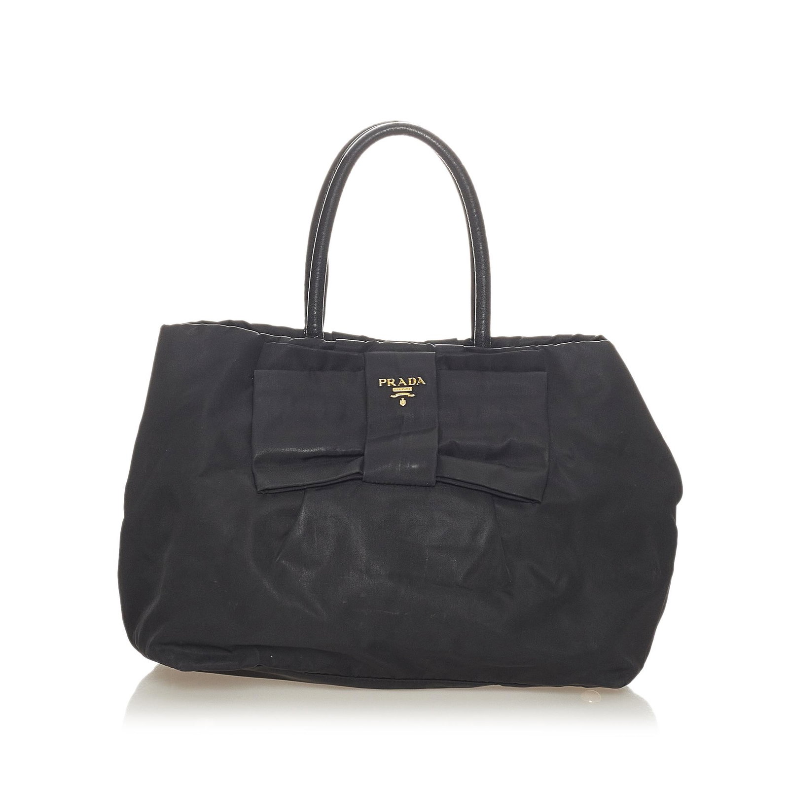 Prada Fiocco Bow Tessuto Handbag: Prada Fiocco Bow Tessuto Handbag This tote bag features a nylon body with a ribbon detail rolled leather handles an open top with a magnetic closure and interior zip pockets. Brand: Prada Model: Fiocc