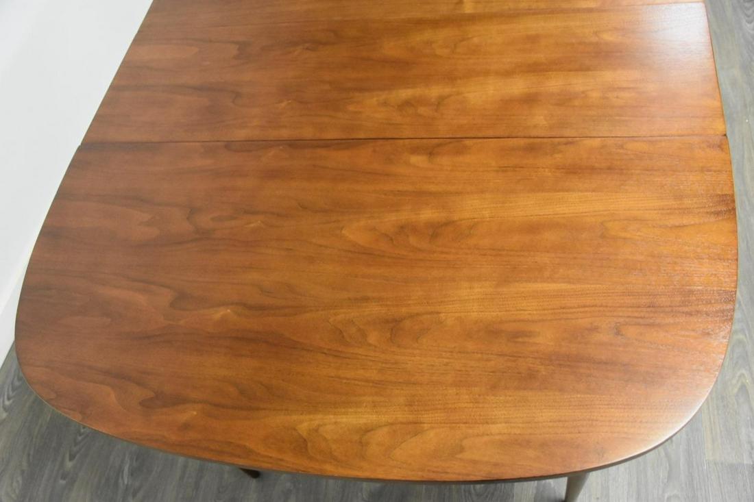 Walnut Extendable Dining Table: Walnut Extendable Dining Table A mid century modern walnut dining table with two 12" leaves that fully extend it to 66" wide. Professionally refinished. 42" wide. 42" deep. 29.5" tall. Dimensions: 42"
