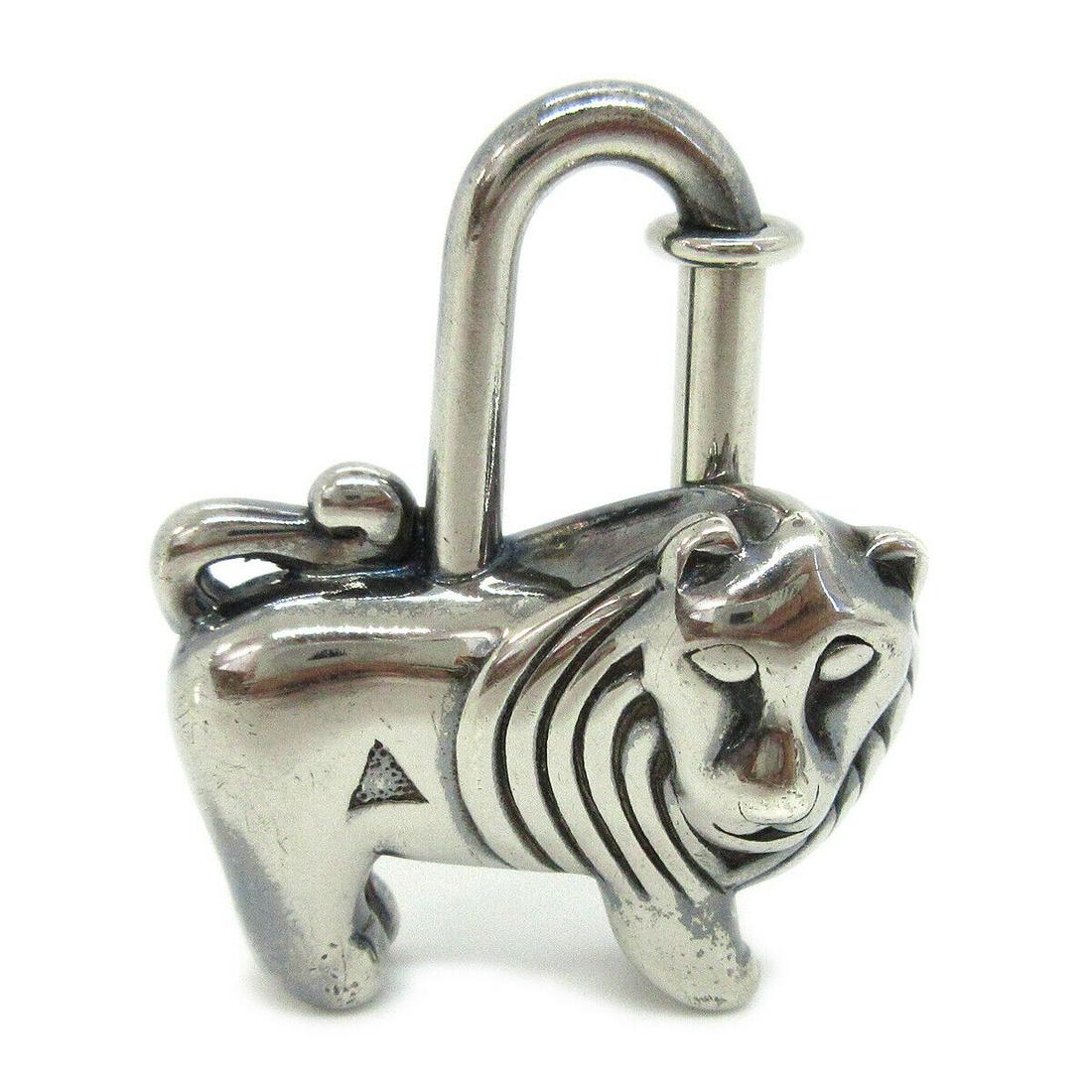 HERMES Lion Motif 1997 Limited Cadena Lock Bag Charm Silver Plated: HERMES Lion Motif 1997 Limited Cadena Lock Bag Charm Silver Plated Outside Condition: C: Heavily Used/Inside Condition: C: Heavily Used The BIDHAUS Guarantee: All items in this auction are guaranteed
