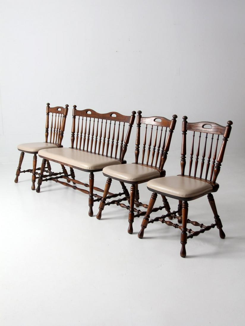 Vintage Oak Dining Chairs And Bench Set 4: Vintage Oak Dining Chairs And Bench Set 4 This is a set of vintage dining chairs and bench circa 1970. The heavy oak dining chairs have cream faux leather upholstered seats. Windsor style chairs with