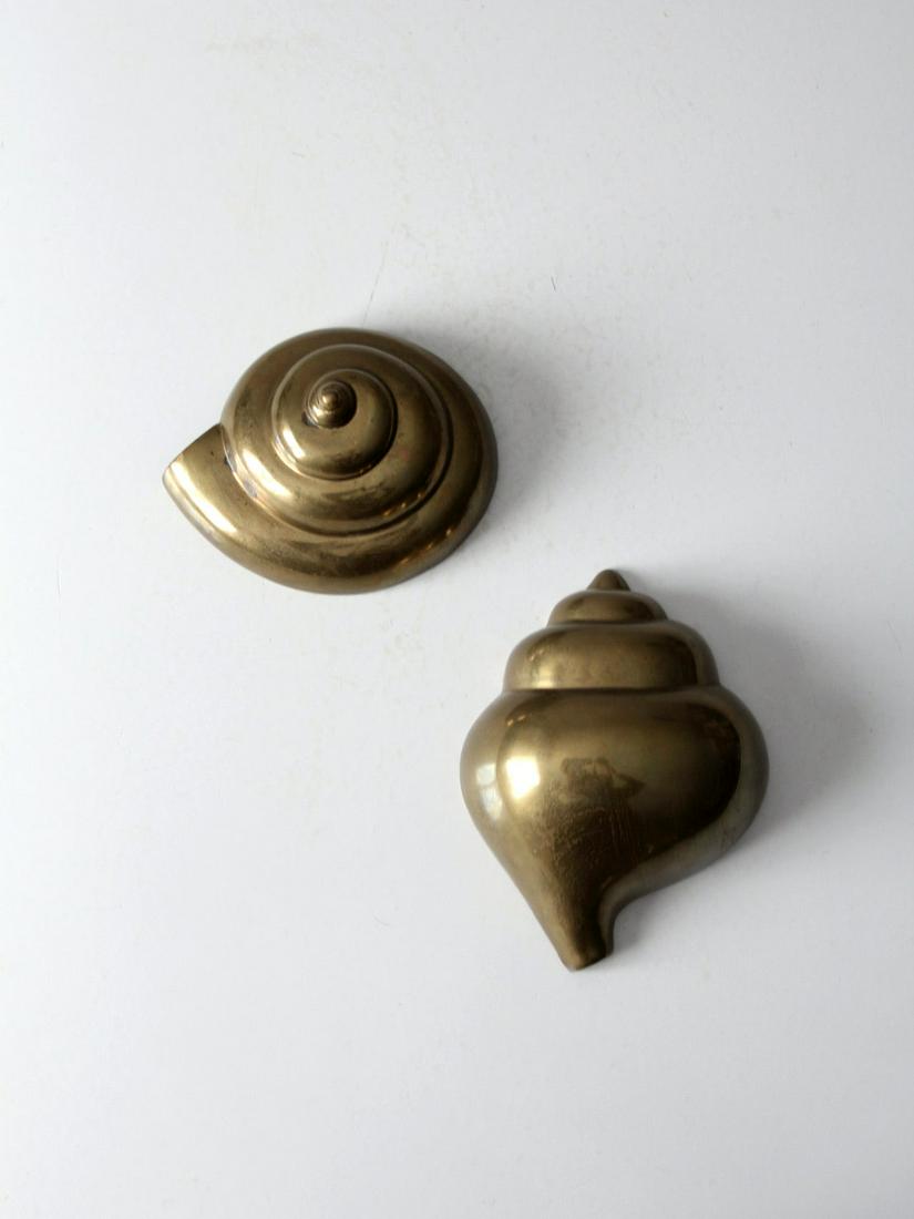 Mid-Century Brass Seashell Wall Decor Pair: Mid-Century Brass Seashell Wall Decor Pair This is a pair of mid 20th century seashell shaped brass wall embellishments. The rich brass tone of the conch shells will make an eye catching element on th