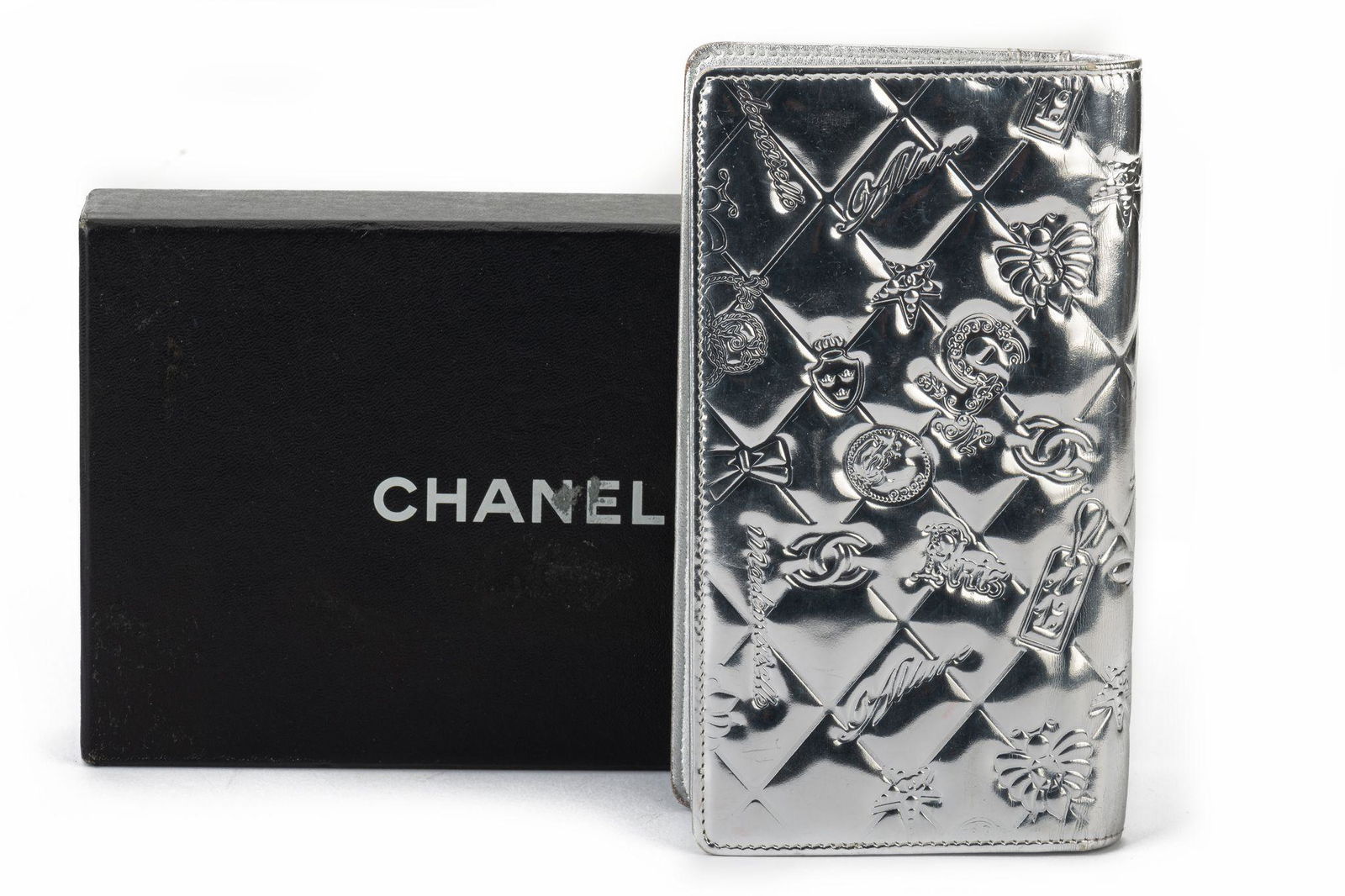 Chanel Preloved Silver Symbols Wallet: Chanel Preloved Silver Symbols Wallet Designer: Chanel Dimensions: Height: 7 in (17.78 cm)Width: 1.25 in (3.18 cm)Length: 4 in (10.16 cm) Period: 21st Century Pre-Owned The BIDHAUS Guarantee: All item