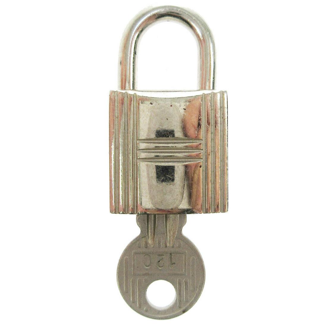 HERMES Set of Padlock & Key Cadena Silver-Tone Bag Accessories Charm: HERMES Set of Padlock & Key Cadena Silver-Tone Bag Accessories Charm Type: Lock Color: Silver Outside Condition: B: Reasonable Wear and Tear/Inside Condition: C: Heavily Used The BIDHAUS Guarantee: Al