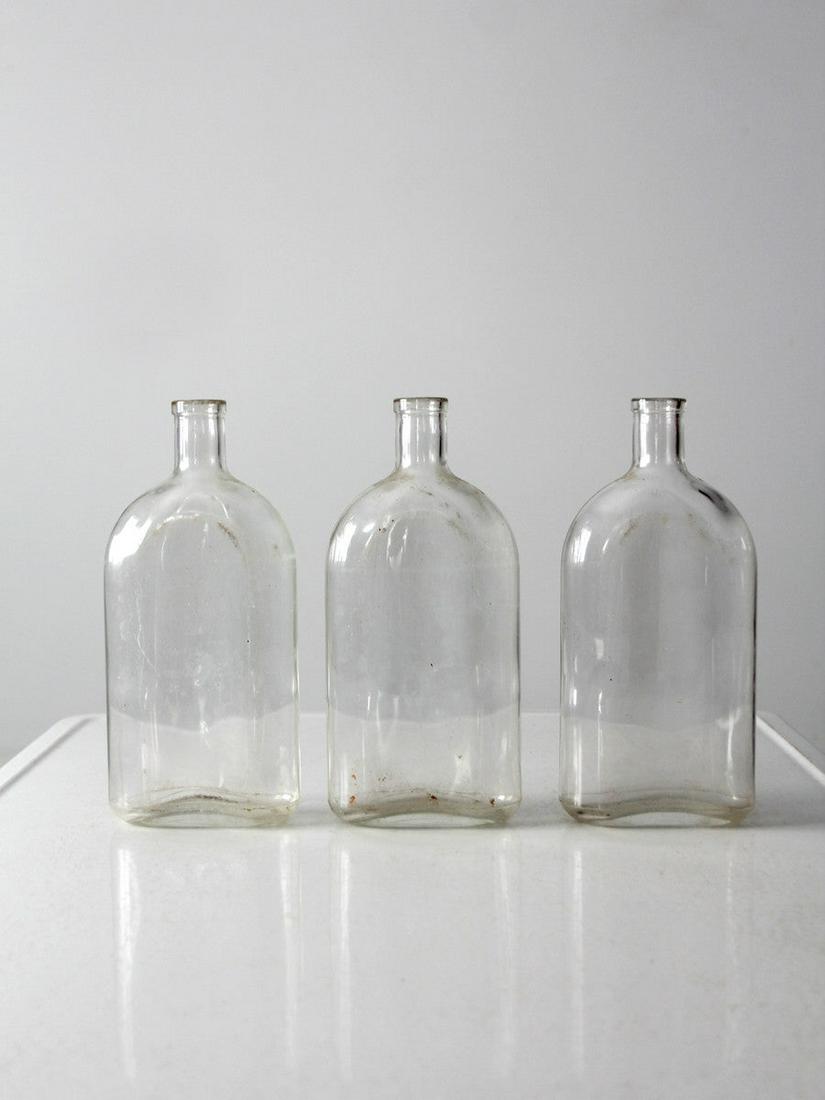 Vintage Pyrex Apothecary Bottle Collection: Vintage Pyrex Apothecary Bottle Collection A collection of three Pyrex apothecary bottles circa 1930. The large clear glass bottles feature a flat base a rounded front body and off-set neck. They are
