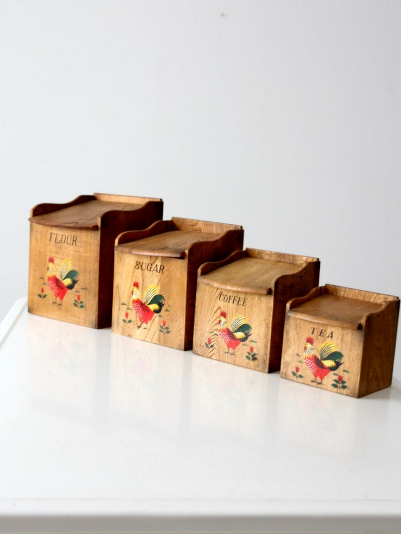 Mid-Century Rooster Kitchen Canisters Set: Mid-Century Rooster Kitchen Canisters Set This is a 1950s era kitchen rooster canisters set. The wooden canisters feature hand painted roosters and lettering. Slanted lids open the set and they have l