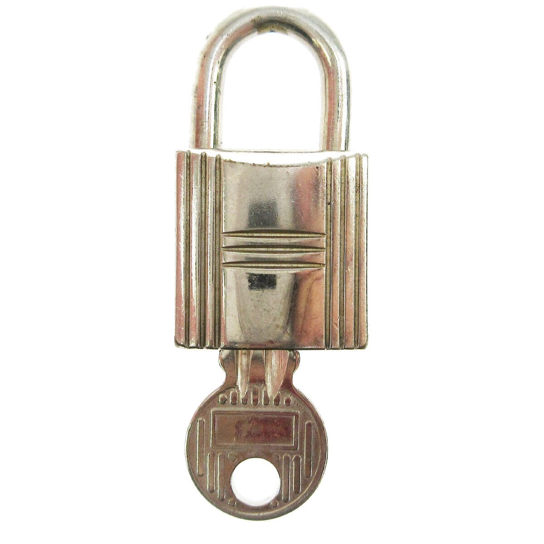 HERMES Set of Padlock & Key Cadena Silver-Tone Bag Accessories Charm: HERMES Set of Padlock & Key Cadena Silver-Tone Bag Accessories Charm Type: Lock Color: Silver Outside Condition: B: Reasonable Wear and Tear/Inside Condition: C: Heavily Used The BIDHAUS Guarantee: Al