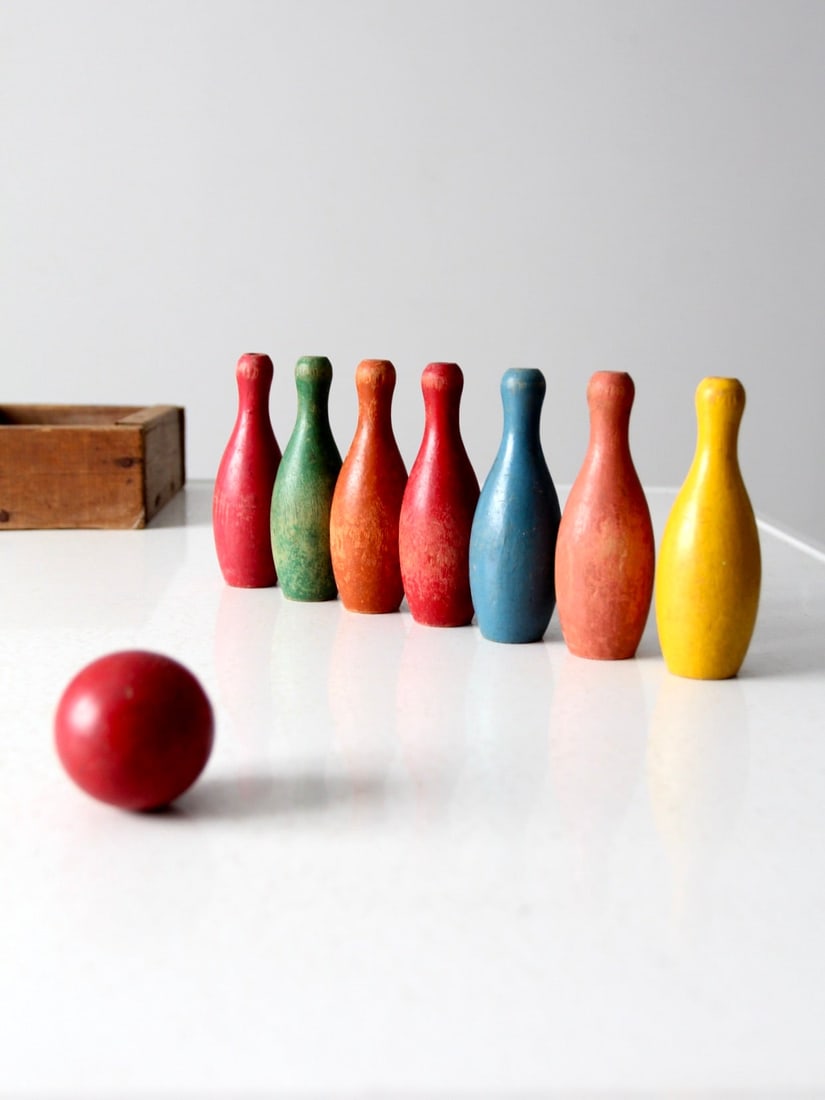 Vintage Wooden Skittles Set: Vintage Wooden Skittles Set This is a vintage wooden tabletop bowling game set. The colorful set features seven skittles in bright playful colors with a red wooden ball and wood box for storage. Box 9