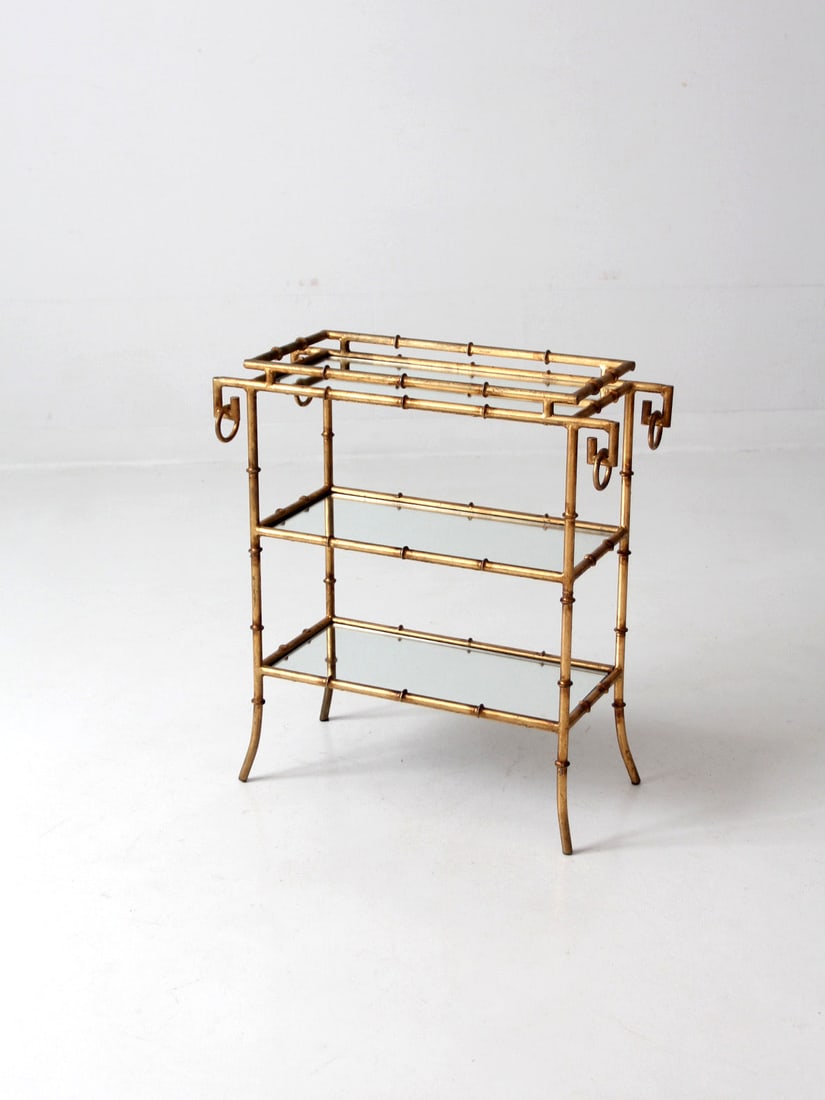 Vintage Gold Bamboo Side Table: Vintage Gold Bamboo Side Table This is a vintage gilt bamboo tray table. The Hollywood Regency style table has three mirrored glass shelves. Height 26 inch 66 cm Width 24 inch 61 cm Depth 11 inch 27.9