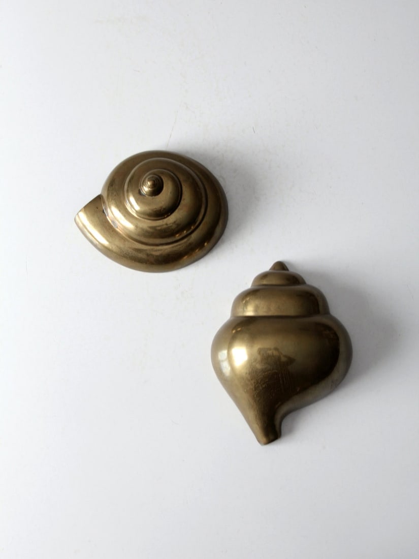 Mid-Century Brass Seashell Wall Decor Pair: Mid-Century Brass Seashell Wall Decor Pair This is a pair of mid 20th century seashell shaped brass wall embellishments. The rich brass tone of the conch shells will make an eye catching element on th