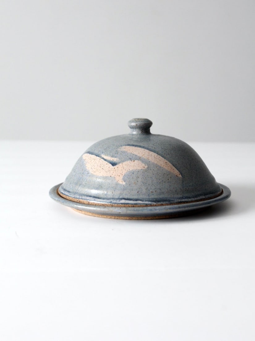 Vintage Studio Pottery Kitchen Cloche: Vintage Studio Pottery Kitchen Cloche This is a vintage studio pottery kitchen cloche. The hand-crafted ceramic cloche features a beautiful speckled blue glaze with cream accents. It has a base plate 