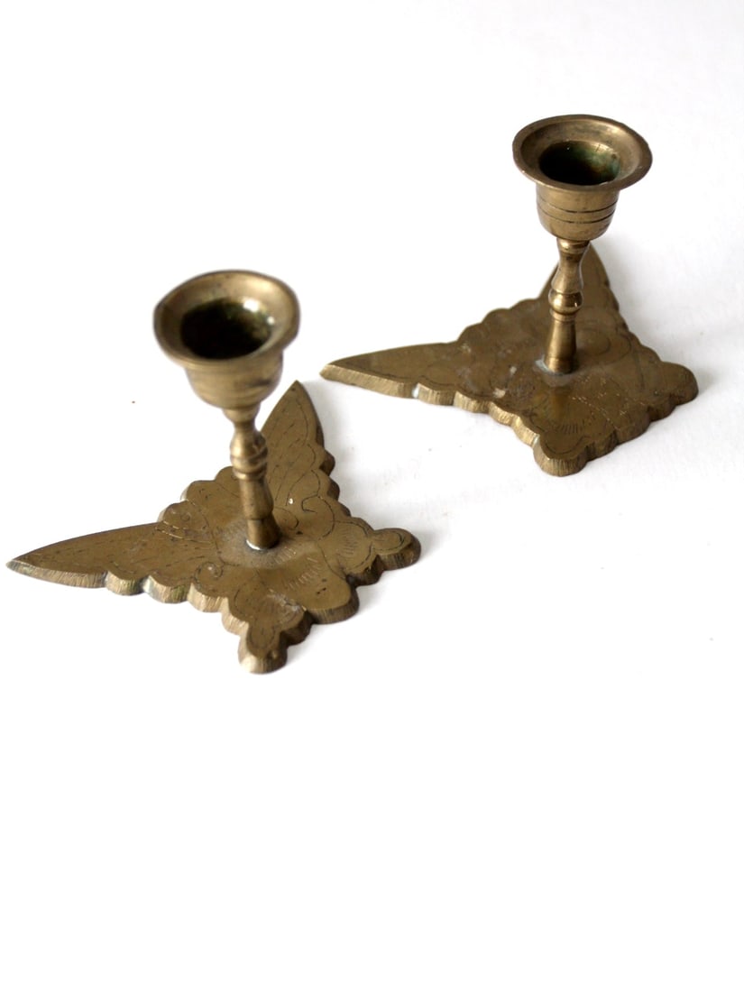 Vintage Brass Butterfly Candle Holders Pair: Vintage Brass Butterfly Candle Holders Pair This is a pair of vintage brass butterfly candleholders. Butterflies shape the base of the candlestick holders that have baluster stems and simple cup-shape