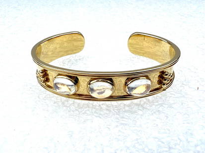 EUROPEAN 18K MOONSTONE BANGLE SIGNED: EUROPEAN 18K MOONSTONE BANGLE SIGNED Type: Bracelet Metal Purity: 18k Style: Bangle Metal: Yellow Gold Main Stone: Moonstone It measures 6.50" long with 1" opening space and 0.50" wide. Each of the tr