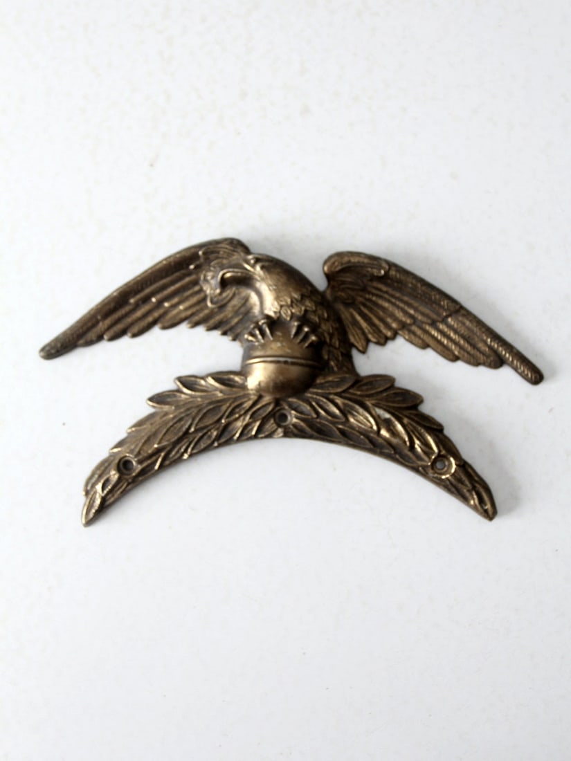 Vintage Brass Eagle Wall Hanging: Vintage Brass Eagle Wall Hanging This vintage brass eagle wall hanging is an elegant addition to any home or office. The detailed design of the American eagle spreading its wings perched atop a sphere