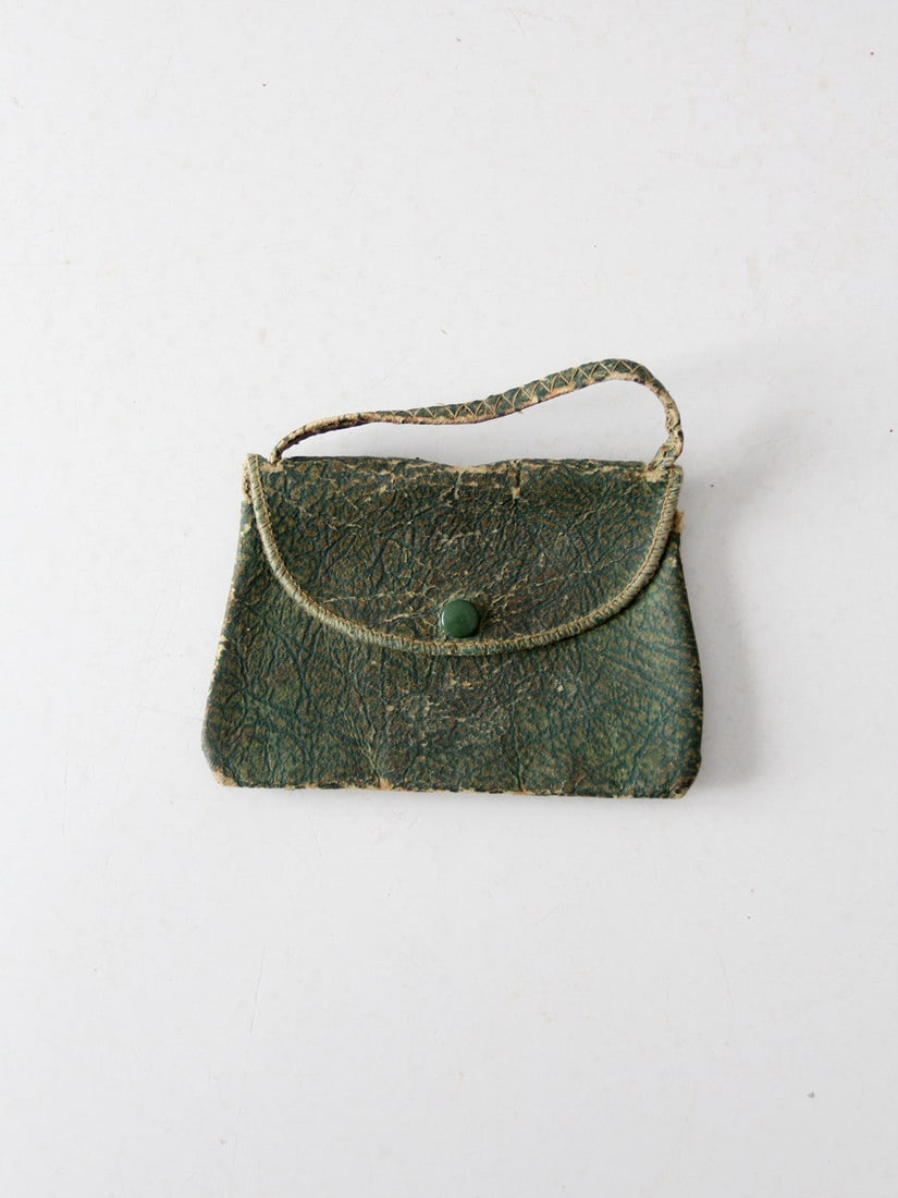 Antique Leather Coin Purse: Antique Leather Coin Purse This is an antique leather coin purse. The little green leather bag features a slender handle with white stitching. It snaps closed and carries a small mirror tucked inside.