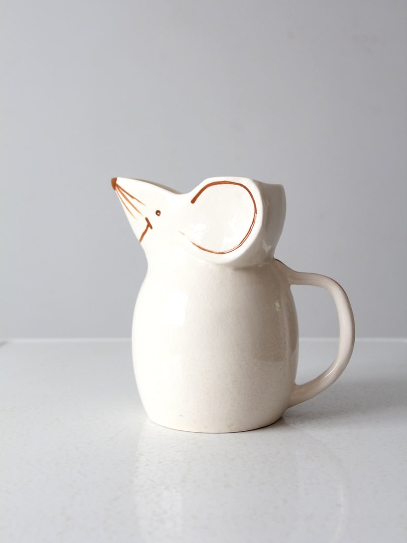 Mid Century Ceramic Mouse Pitcher: Mid Century Ceramic Mouse Pitcher Cheer up your kitchen with this adorable vintage ceramic pitcher! It's shaped like an irresistibly grinning mouse and has a tail handle - how cute is that?! This mid 