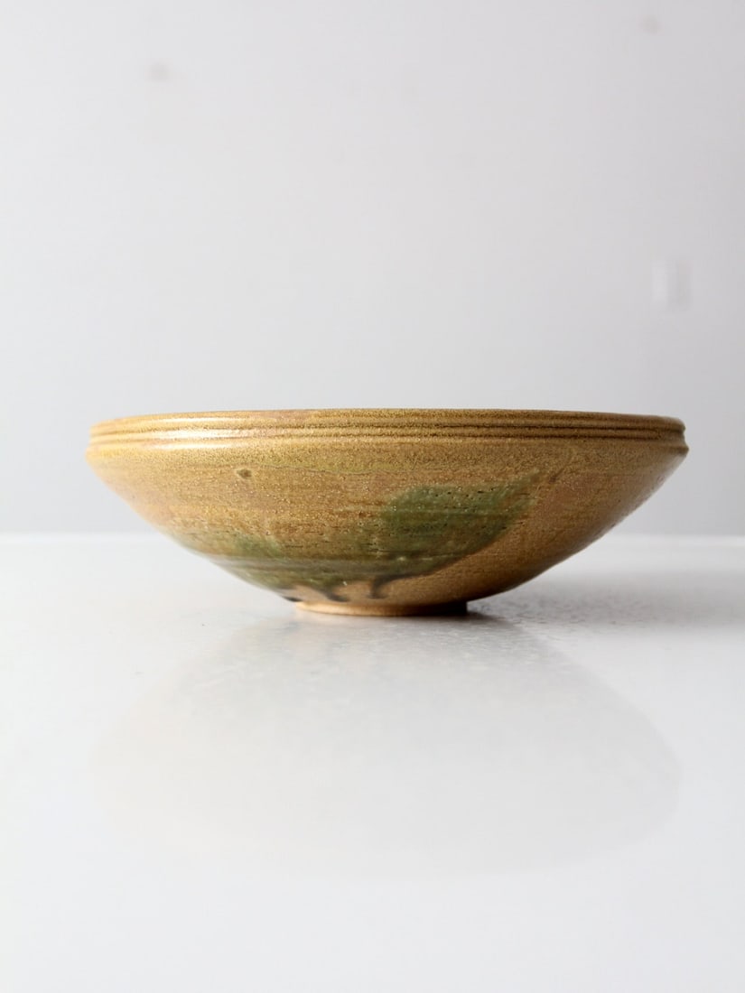 Vintage Studio Pottery Bowl: Vintage Studio Pottery Bowl This is a vintage studio pottery bowl. Signed by the artist the hand-crafted bowl features a tan and grass green glaze. Diameter 9.25 inch 23.5 cm Height 2.875 inch 7.3 cm 